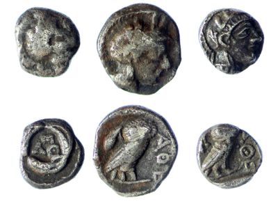 six ancient silver coins with different designs on them on a white surface