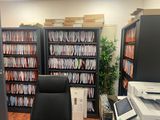 a desk with a laptop and a printer in a room with bookshelves