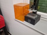 a microwave sitting on a window sill next to a red chair