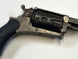 un petit pistolet posé sur une surface blanche