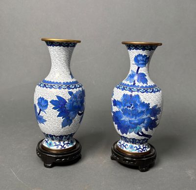 pair of blue and white vases sitting on top of a wooden stand