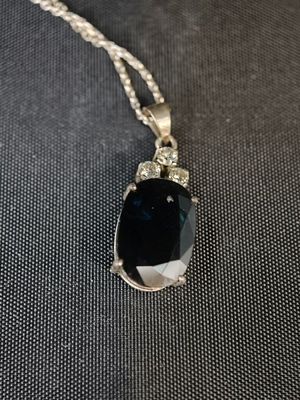 un collier orné d'une grosse pierre noire montée sur une chaîne en argent