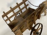 an old wooden wagon with a chain attached to it sitting on a floor