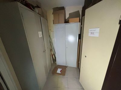 a white refrigerator in a room with a lot of boxes on the floor