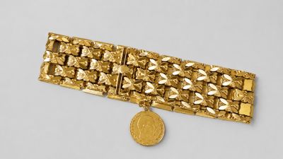 l'image d'un bracelet en or surmonté d'une pièce de monnaie