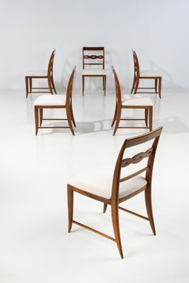 several chairs are arranged in a circle in a white room