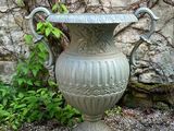 a large vase that is sitting in the gravel