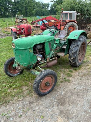un tracteur vert qui est garé dans l'herbe