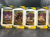 trois paquets de cartes à collectionner Pokémon posés sur une table