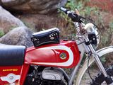 a red and white motorcycle parked next to some rocks