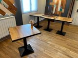 two tables with a vase of flowers on them in a room