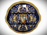 a blue and gold plate with a picture of angels on it