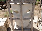 a white toilet sitting on a pallet next to a pile of boxes