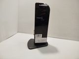 a black cell phone sitting on a stand on a table
