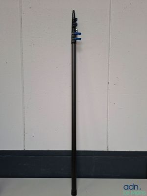 a black pole with a blue handle on the floor