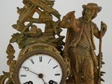 a statue of a man and a clock on a table