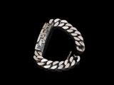 gros plan d'un bracelet en argent sur fond noir