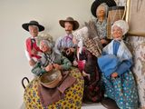 de nombreuses figurines représentant des personnes, posées sur une étagère
