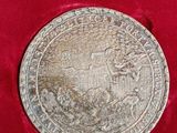 an old silver medal with a horse on it in a red velvet case