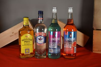 several bottles of alcohol are lined up on a red table