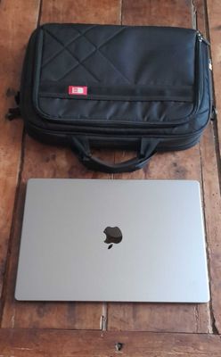 a laptop and a bag on a wooden floor