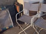 deux chaises pliantes et une valise posées par terre