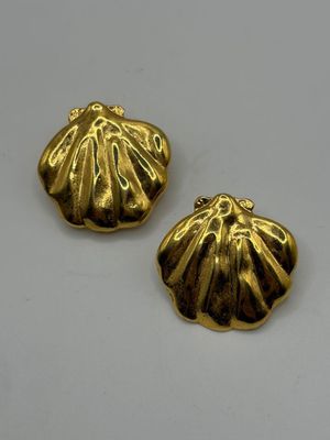 two gold plated shells on a white surface