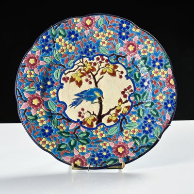 a colorful plate with a bird on it on a stand