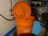 un seau orange posé sur une table bleue