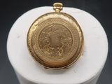 an image of a gold pocket watch sitting on top of a white pedestal