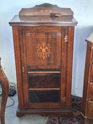 une petite armoire en bois surmontée d'un miroir