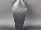 Collier plaqué argent avec pendentif en forme d'éléphant, présenté sur un présentoir pour mannequin