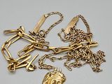 plusieurs colliers en or et un porte-clés en or posés sur une surface blanche