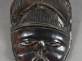 an image of a wooden mask on a white surface