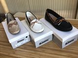 three pairs of women ' s boat shoes on display on a table