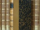 un livre posé sur une table, devant une pile de livres