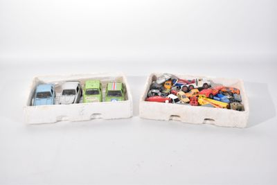 deux petites voitures miniatures se trouvent dans une boîte posée sur une surface blanche