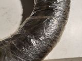 a large metal pipe wrapped in plastic sitting on the floor