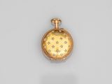 une image représentant une montre de poche en or et diamants posée sur une surface blanche