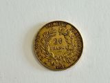 a gold coin on a white surface with a white background