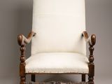 an old chair with a white upholstered seat and wooden legs