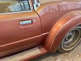 a rusted car parked on the side of the road