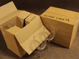 deux verres à vin vides dans une boîte en carton posée par terre