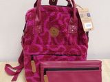 a pink purse and wallet sitting on top of a wooden table