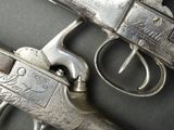 a gun that is sitting next to a pair of scissors
