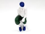 a figurine of a man sitting on top of a toilet