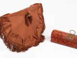 a brown umbrella and a brown purse on a white surface