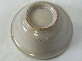 a white bowl with a brown rim sitting on a table