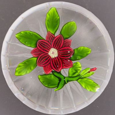 une assiette en verre ornée d'une fleur, posée sur une table