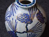 a blue and white vase sitting on a black surface